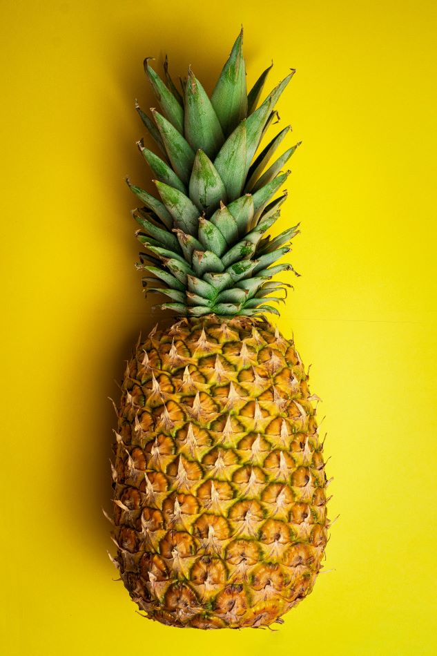 a pineapple set against a yellow background