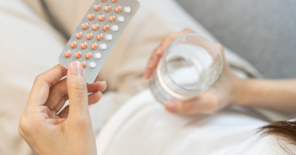 woman hand holding hormonal oral contraceptive medicine