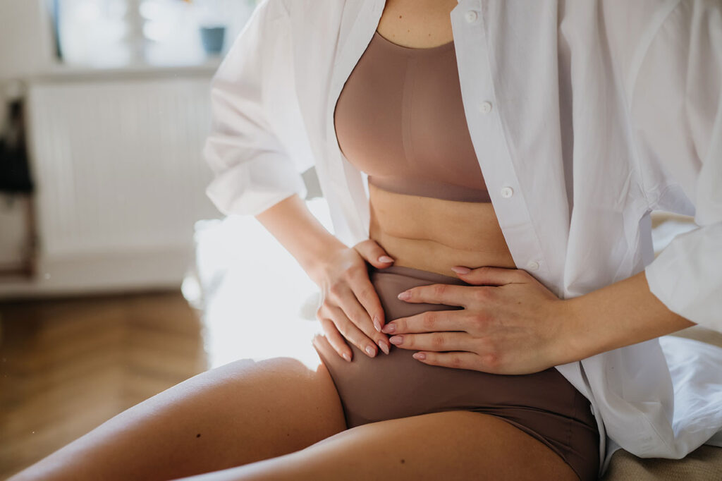 woman in underwear holding hand over waist